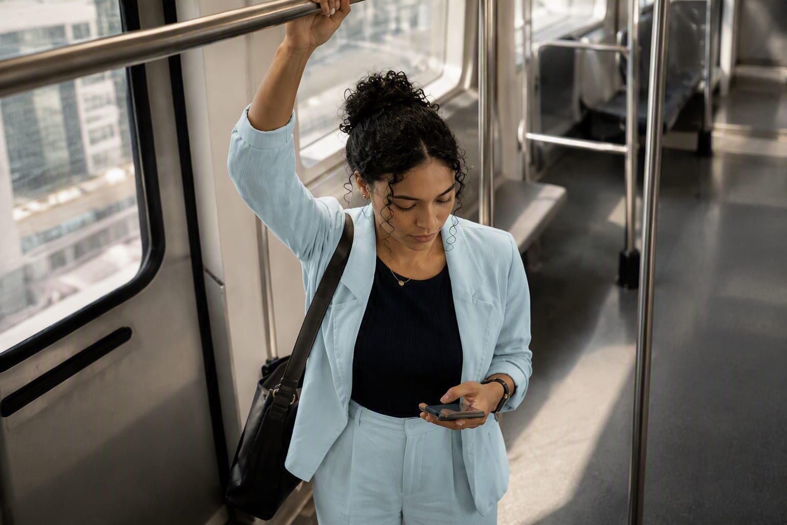 Passageira usando o celular no metrô